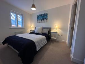 a bedroom with a bed and two tables and two lamps at House Launton Village - close to Tythe Barn, Blenheim Palace & Bicester Shopping in Launton