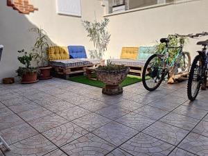 a bike parked on a patio with a bench and chairs at Villa au cœur de la station - 1540 in Soulac-sur-Mer