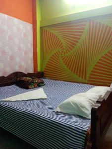 a bedroom with a bed with a colorful wall at India Tours Only Nona Mati in Gosāba