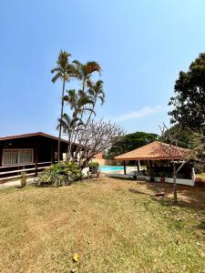una casa con piscina e palme di Chácara / Casa de Campo a Bragança Paulista