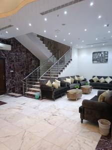 a living room with couches and a staircase at فندق رفاق Refaq Hotel in Makkah