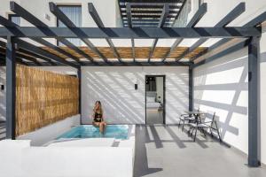 a woman sitting in a hot tub in a house at Blé Suites Santorini in Imerovigli
