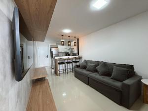 a living room with a couch and a kitchen at Apartamento em Arraial do Cabo in Arraial do Cabo
