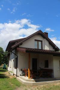 a small white house with a porch at Kwatera agroturystyczna Przywóz in Przywóz