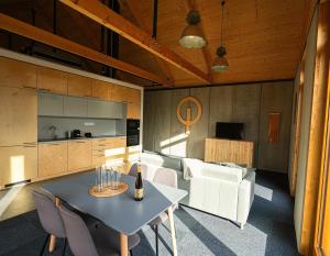 a kitchen and living room with a table and chairs at Optimist apartmanház Velence in Velence
