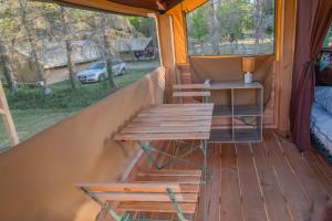 a porch of a tent with a table and chairs at Onlycamp L'Orée des Vosges in Le Val-dʼAjol