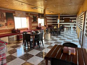 a restaurant with tables and chairs on a checkered floor at Petra Royal Ranch in Wadi Musa