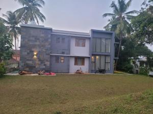 a house with a large yard in front of it at Aurora-The Pool Villa in Kozhikode