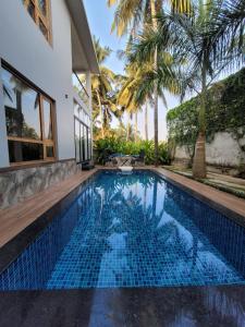a swimming pool in the backyard of a house with palm trees at Aurora-The Pool Villa in Kozhikode