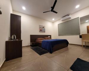 a bedroom with a bed and a flat screen tv at Aurora-The Pool Villa in Kozhikode