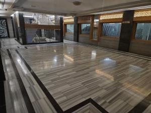 a lobby with a wooden floor and windows at In Apartments in Jeddah