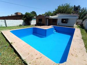 a large blue swimming pool in a yard at Alojamiento Esparta in Villa Carlos Paz