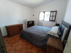 a bedroom with a bed and a dresser and a window at Alojamiento Esparta in Villa Carlos Paz +4 photos