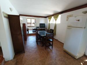 a kitchen with a table and a refrigerator at Alojamiento Esparta in Villa Carlos Paz