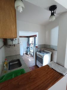 a kitchen with a sink and a stove at Alojamiento Esparta in Villa Carlos Paz