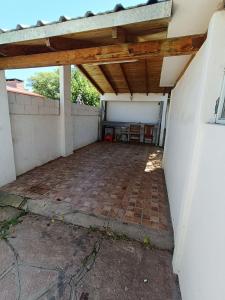 a garage with a brick floor and a wooden roof at Alojamiento Esparta in Villa Carlos Paz