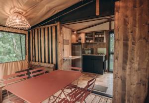 a kitchen and dining room with a table and chairs at Camping Onlycamp Le Petit Port in Châtel-Censoir