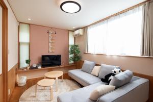 田边市闘鶏の家的客厅里有一张沙发和一台电视