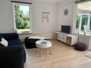 Μια τηλεόραση ή/και κέντρο ψυχαγωγίας στο Coastal hideaway bungalow with garden