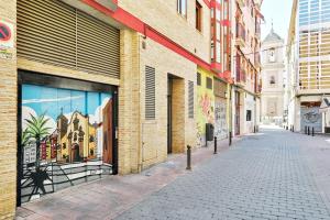 een lege straat met een gebouw met een muurschildering van een kerk bij Apt 1B LuxuryRentalsMurcia in Murcia
