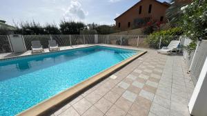 a swimming pool with chairs next to a fence at La Case Du Lagon in Oyster Pond
