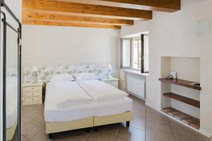 Un dormitorio blanco con una cama y una ventana. en Il Nido dei Gufi Bed and Breakfast, en Toscolano Maderno