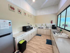 a large kitchen with a sink and a refrigerator at Mountain Lodge, Radiant Janda Baik in Bentong