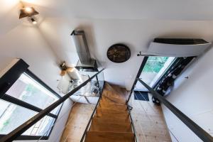 a staircase in a house with white walls and windows at L'armurerie proche Islette et Azay le Rideau in Cheillé