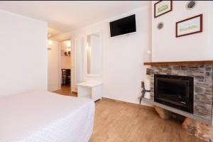 a white bedroom with a fireplace and a bed at Amiata Romantica in Bagnolo