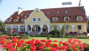 duży budynek z kwiatami przed nim w obiekcie Barokk Hotel w mieście Hegyeshalom