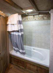 y baño con bañera y cortina de ducha. en Charming 2BR Getaway Near Fredericksburgs Best Wineries, en Fredericksburg