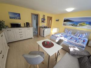 Un dormitorio con una cama y una mesa y sillas. en Kleiner Bungalow Wiesenperle, en Trassenheide