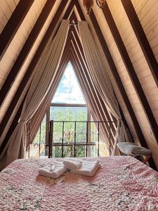 ein Zimmer mit einem Bett in einem Zelt mit einem Fenster in der Unterkunft Chalé Charlotte l Maravilhoso para Casal in Campos do Jordão