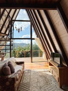 Zimmer mit Sofa und TV im Dachgeschoss in der Unterkunft Chalé Charlotte l Maravilhoso para Casal in Campos do Jordão