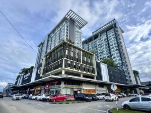 a large building with cars parked in a parking lot at MetroCity Square Condominium-3R2B-9 Pax in Kuching