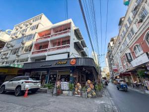 a building on a city street with a store at JC House Hotel in Pratunam