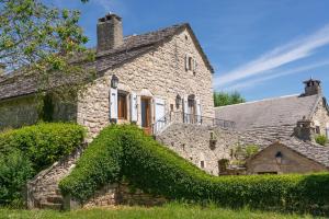 an old stone house with ivy growing on it at Gîte Le Bellevue 4/6 personnes du Couvent in Saint-Georges-de-Lévéjac