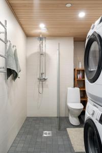 a bathroom with a toilet and a shower and a washing machine at Modern 1BR Apartment with Balcony at Tripla Pasila, 5 mins to Helsinki City Center in Helsinki +40 photos