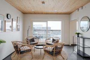 a living room with chairs and a table at Modern 1BR Apartment with Balcony at Tripla Pasila, 5 mins to Helsinki City Center in Helsinki