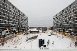 a large building with a snow covered courtyard in front of it at Modern 1BR Apartment with Balcony at Tripla Pasila, 5 mins to Helsinki City Center in Helsinki