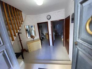 a hallway with a staircase and a clock on the wall at Don Pasquale Scontrone House in Scontrone