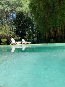 two chairs sitting next to a swimming pool at Casa Quinta Guacaras in Santa Ana