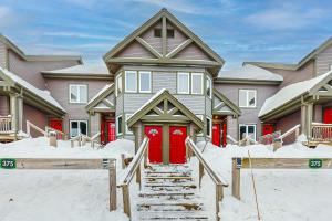 a house with red doors in the snow at Jay Peak Village Home 375 in Jay