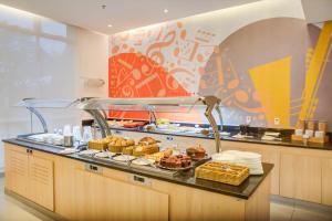 a breakfast buffet with pastries and bread on a counter at Transamerica Fit Jacareí in Jacareí