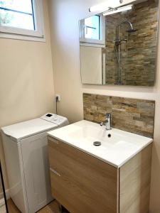 ein Badezimmer mit Waschbecken und Waschmaschine in der Unterkunft La villa Kikifil, bord de mer in Saint-Germain-sur-Ay