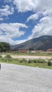 a dirt road with mountains in the background and a sky with clouds at Casa Doña Elsa - amoblada ideal descanso en Volcán - Jujuy in Volcán