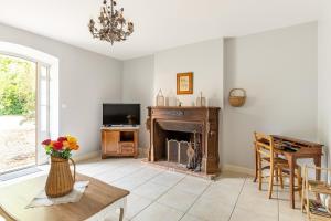 a living room with a fireplace and a tv at Domaine de la Garnauderie Gîte des Chênes in Sainte-Maure-de-Touraine
