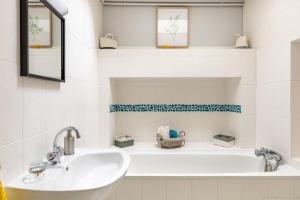 a white bathroom with a sink and a tub at Domaine de la Garnauderie Gîte des Chênes in Sainte-Maure-de-Touraine +64 photos