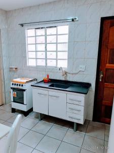 a kitchen with a sink and a stove at Casa do Anderson in Guarulhos +3 photos
