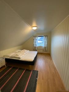 a small bedroom with a bed and a window at Inger- og Petterhuset in Sørvågen